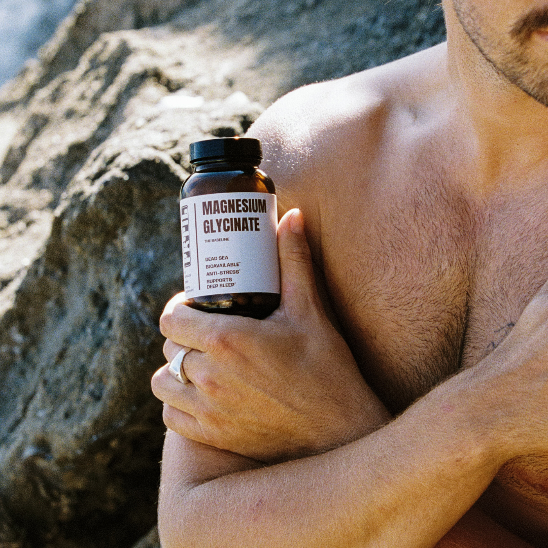 Man holding FRTIL magnesium glycinate supplement for stress and sleep support outdoors